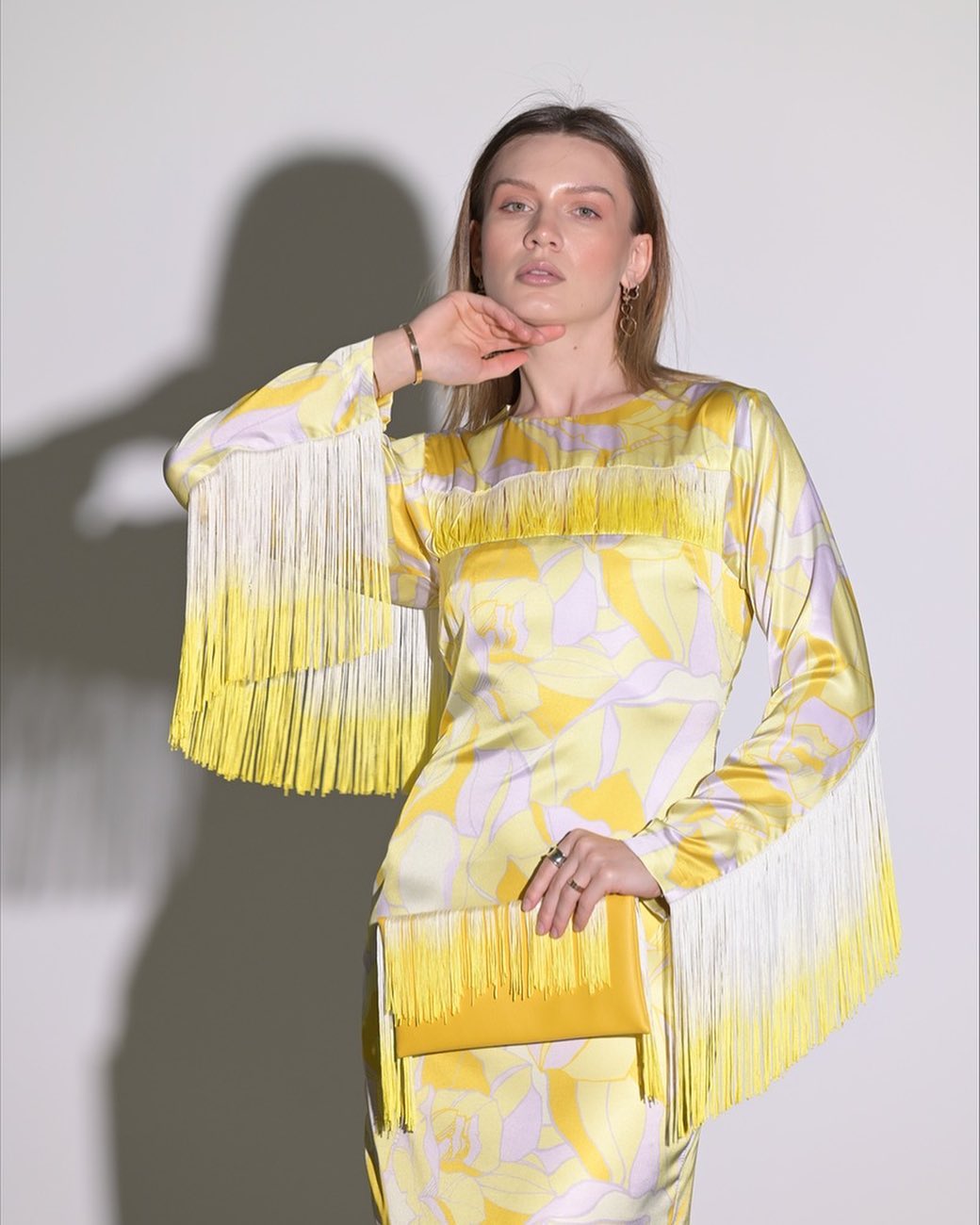 Yellow silky dress with small rope accessories on the sleeves and hem