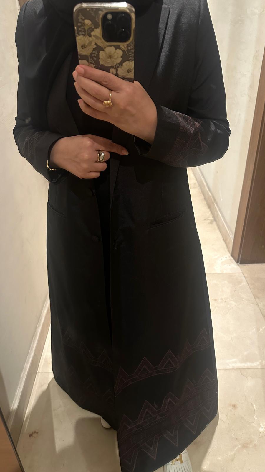 Elegant black abaya with pockets and decorations at the bottom